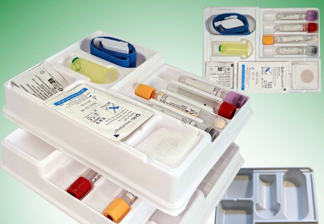 The thermoformed tray, filled with equipment for blood sampling