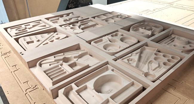 Eleven thermoforming molds displayed on the CNC machine